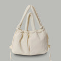 PLSH beige women’s designer puffer handbag on a beige background