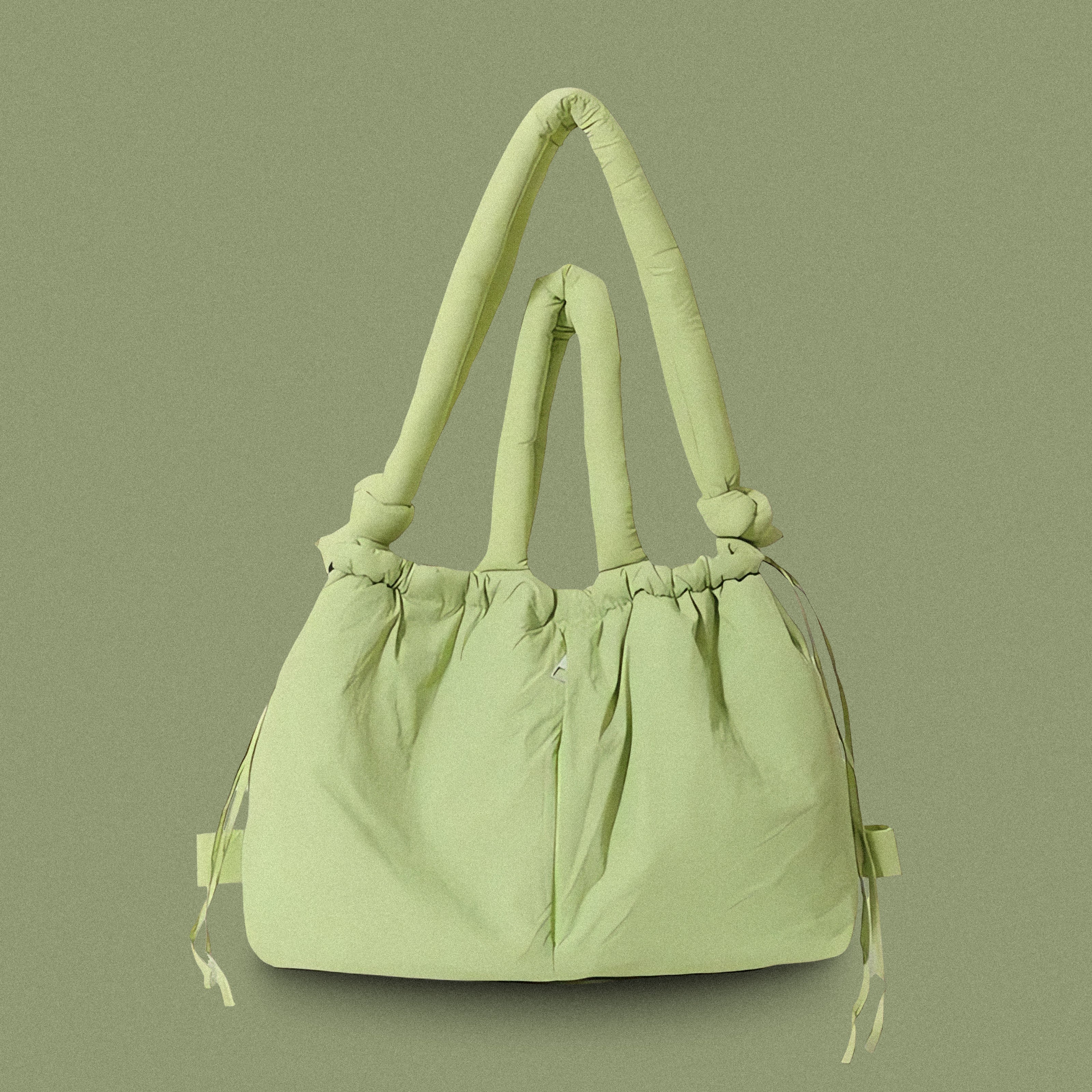 PLSH lime green women’s designer puffer handbag on a green background