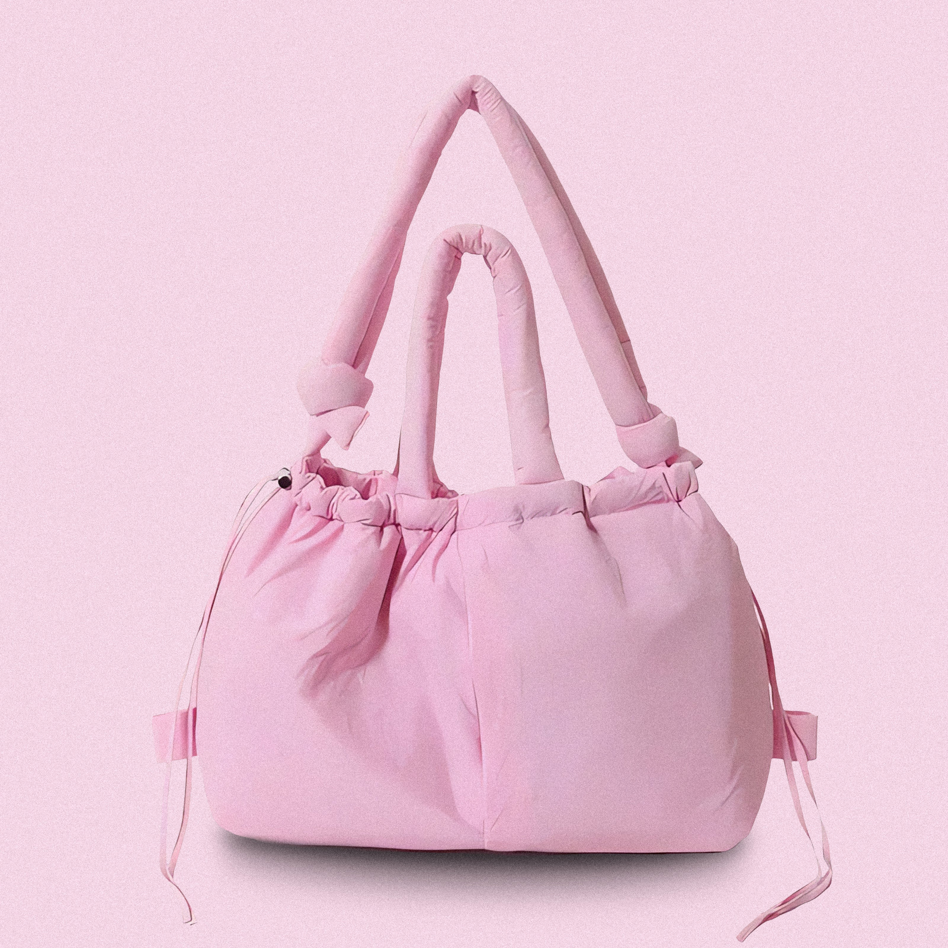 PLSH pink women’s designer puffer handbag on a pink background