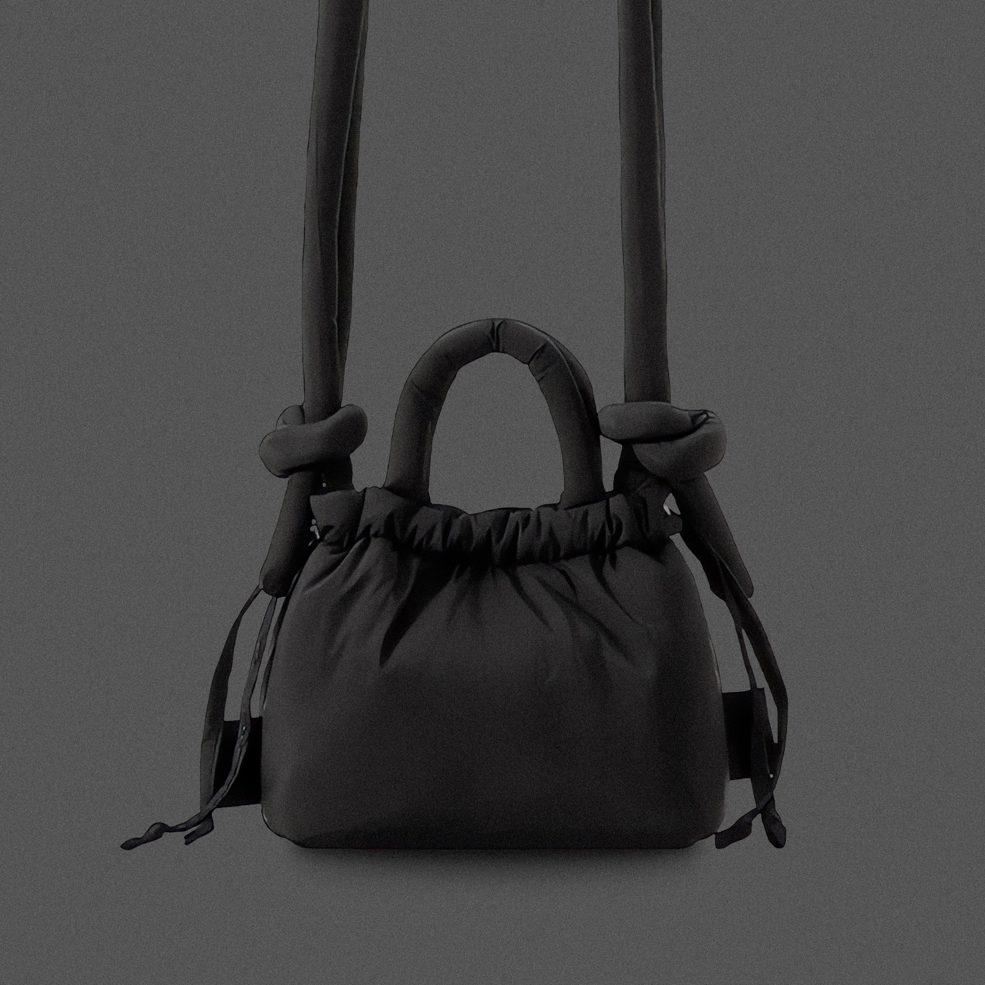 PLSH black women’s designer puffer handbag on a black background