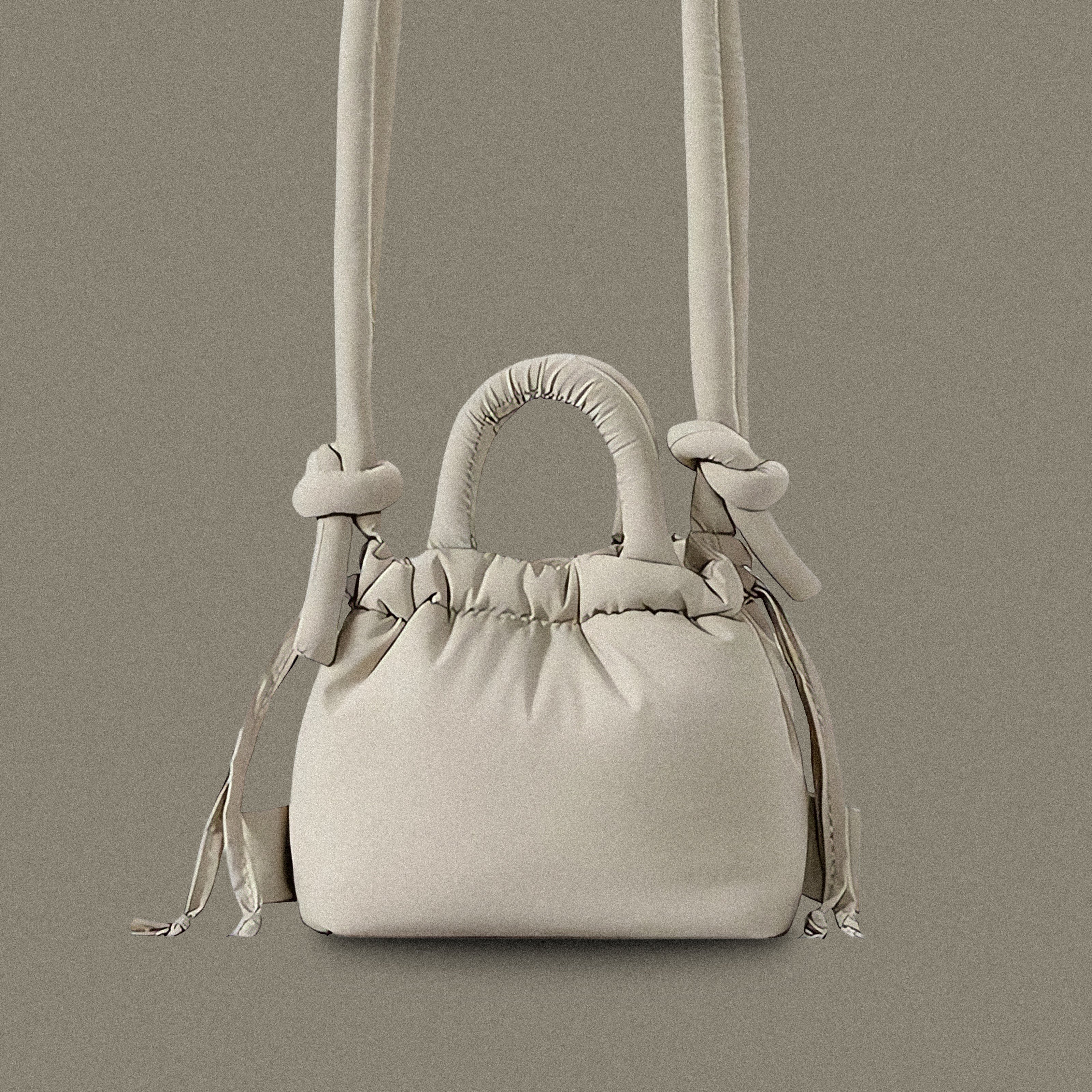 PLSH light gray women’s designer puffer handbag on a gray background