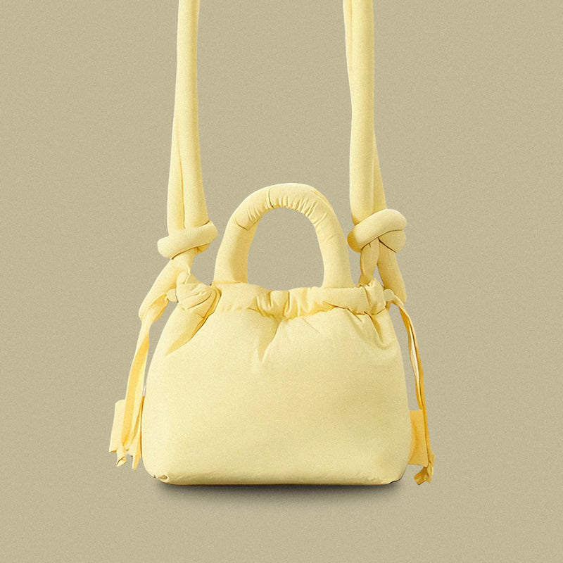 PLSH yellow women’s designer puffer handbag on a yellow background