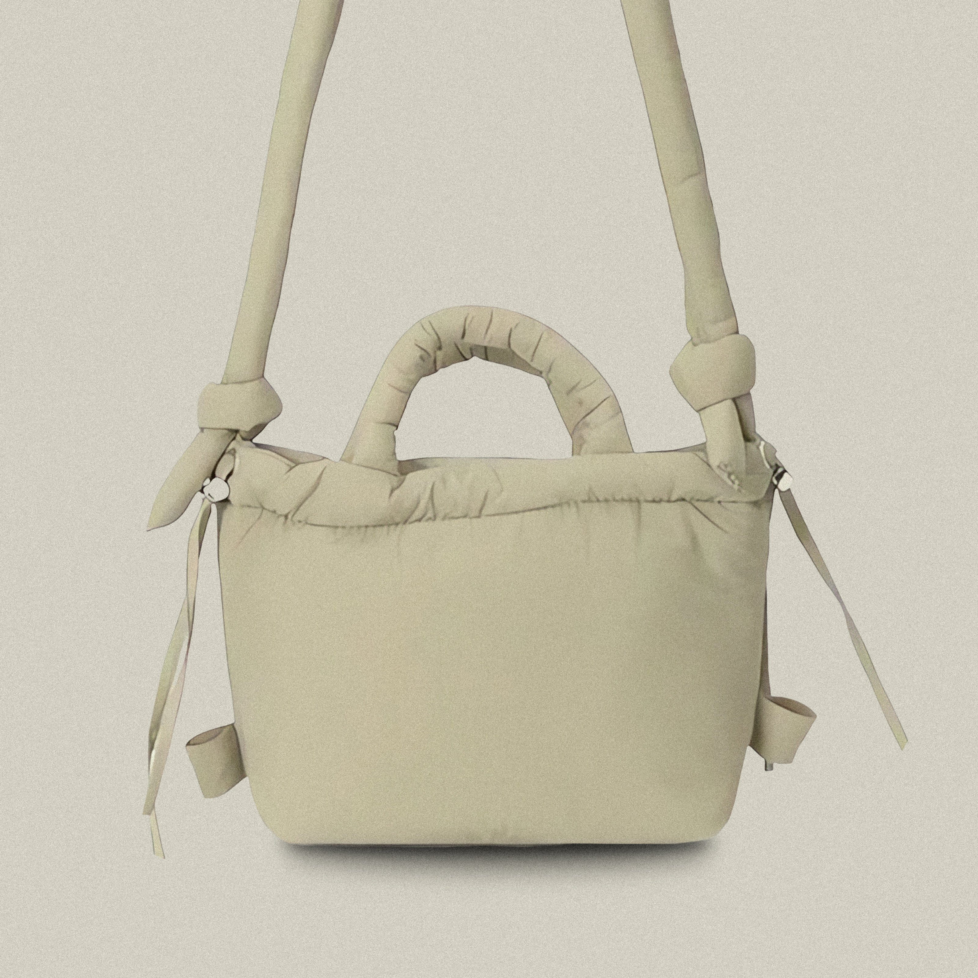 PLSH beige women’s designer puffer handbag on a white background