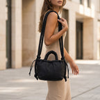 Woman wearing a PLSH black designer handbag in an urban setting