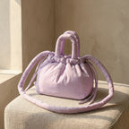 PLSH lilac women's designer handbag on a beige cushion with a neutral background