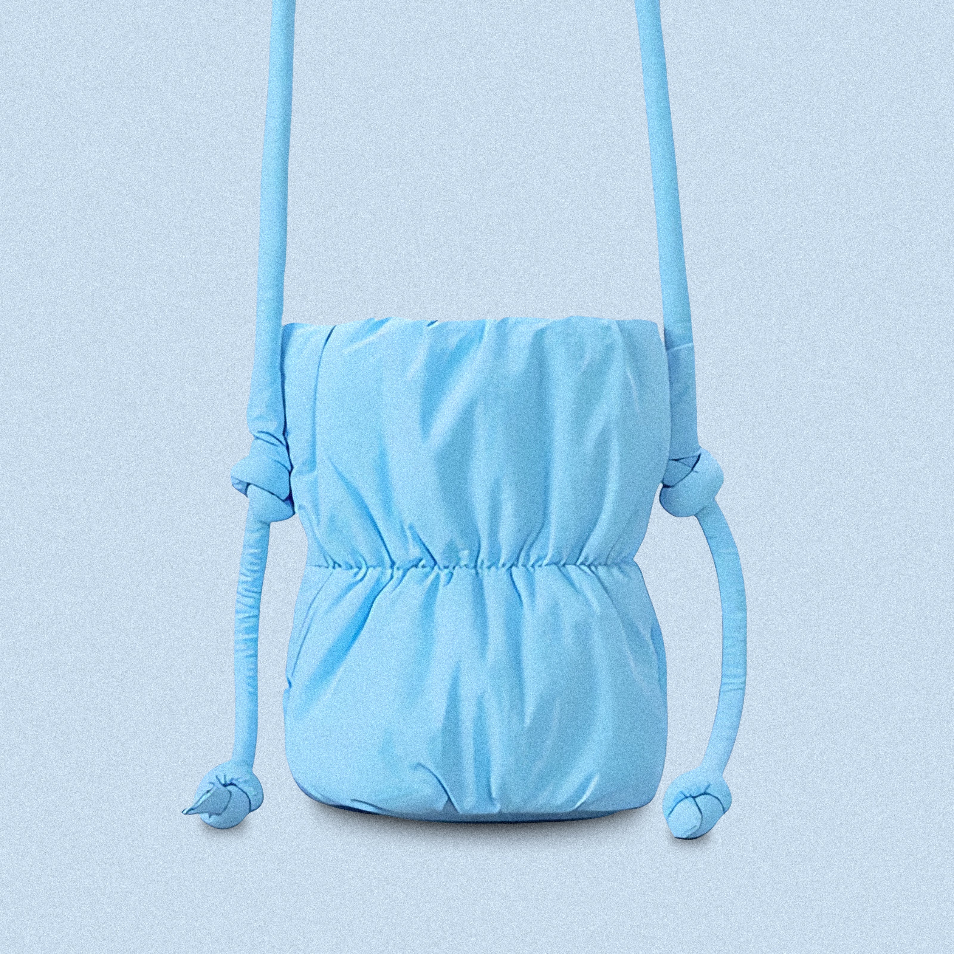 PLSH blue women’s designer puffer handbag on a blue background