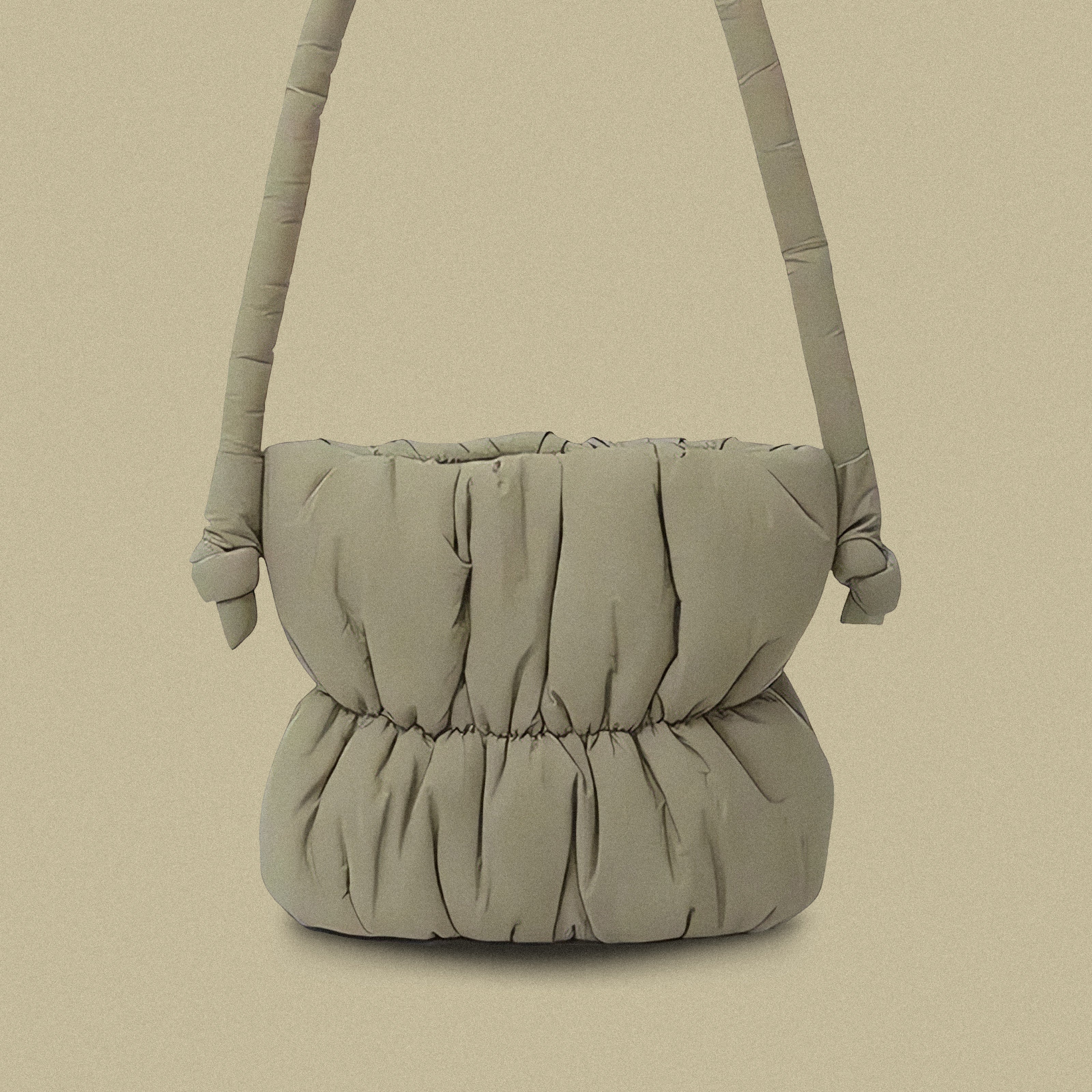 PLSH taupe women’s designer puffer handbag on a taupe background