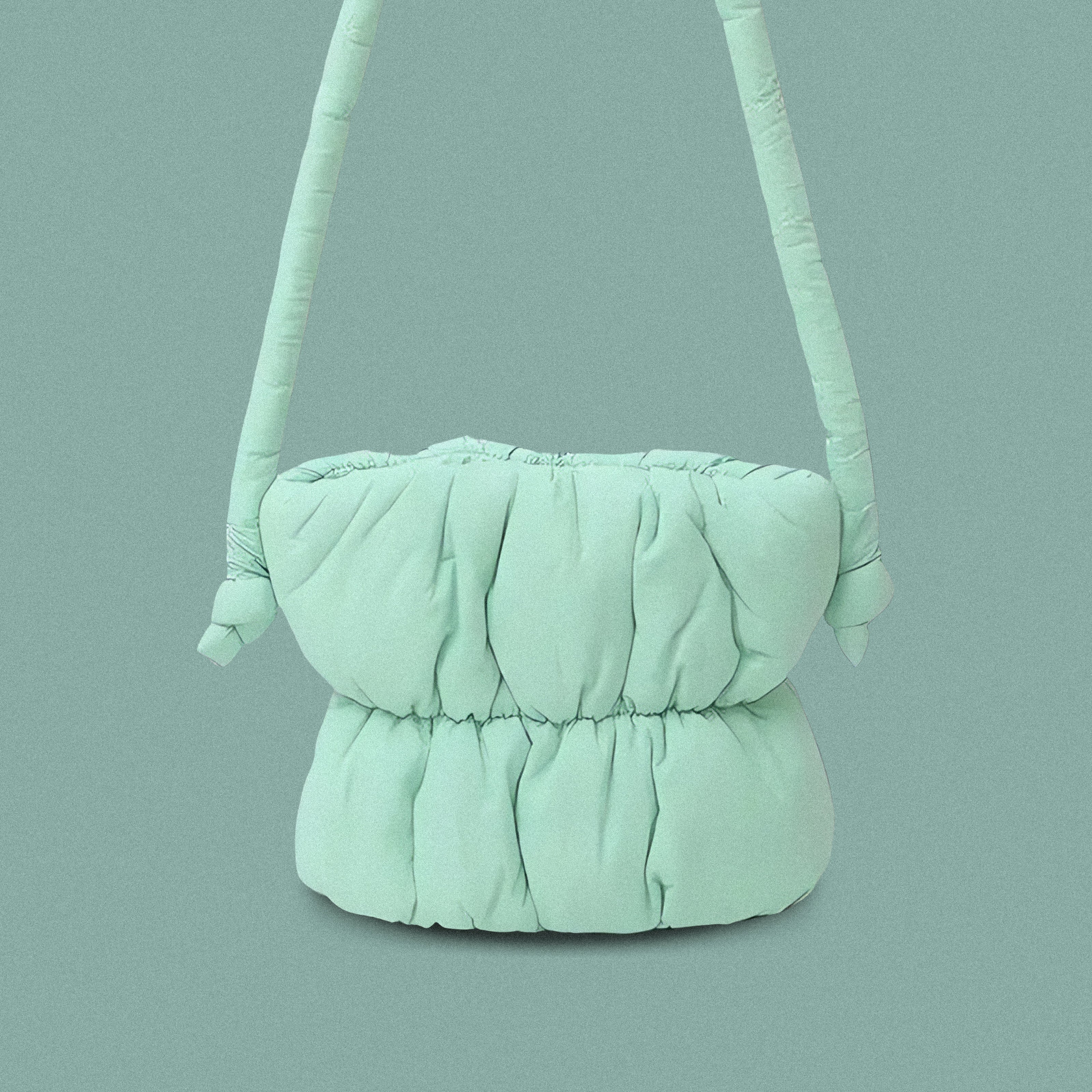 PLSH teal women’s designer puffer handbag on a teal background