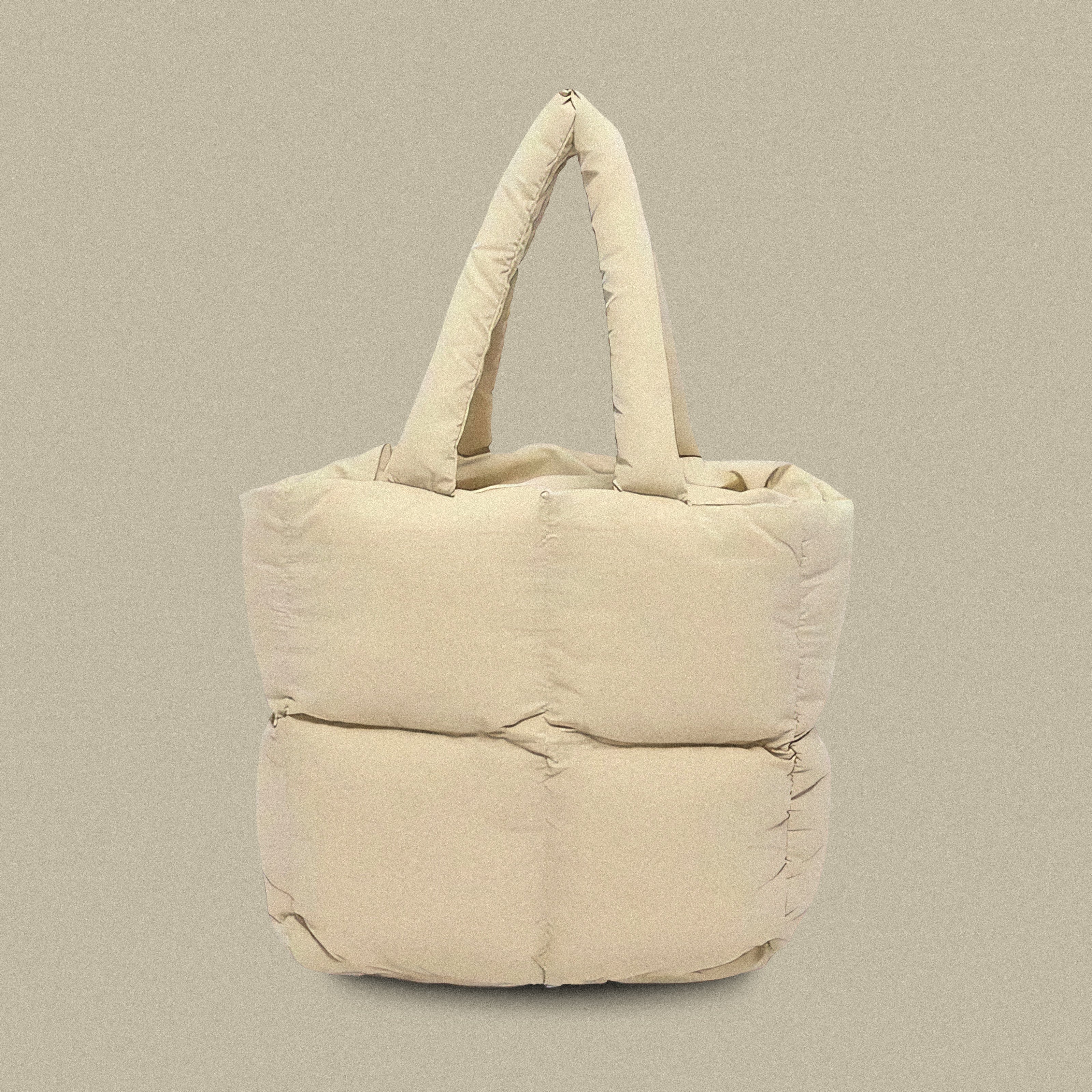 PLSH beige women’s designer puffer handbag on a beige background