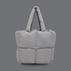 PLSH light gray women’s designer puffer handbag on a gray background