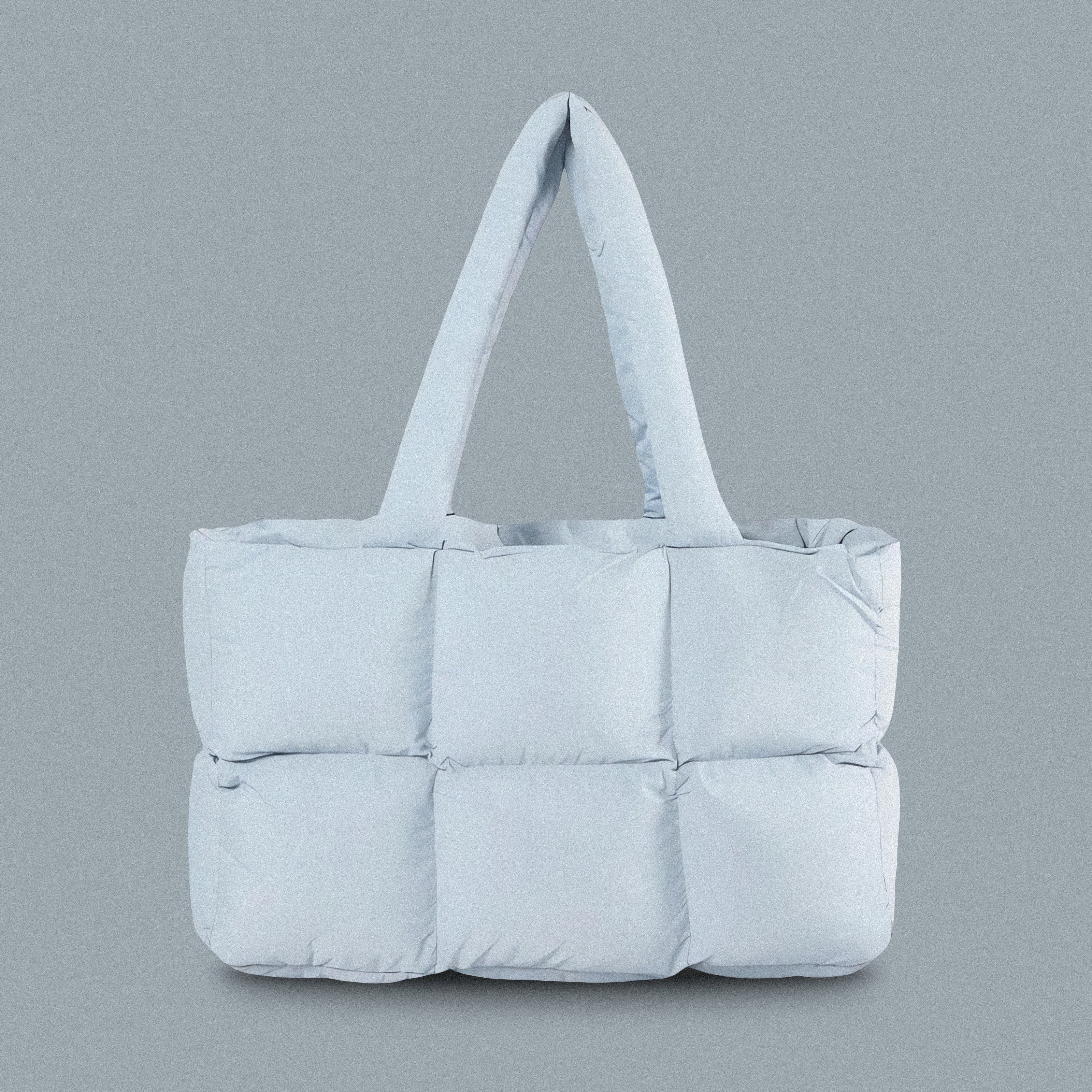 PLSH baby blue women's designer puffer handbag on a blue background