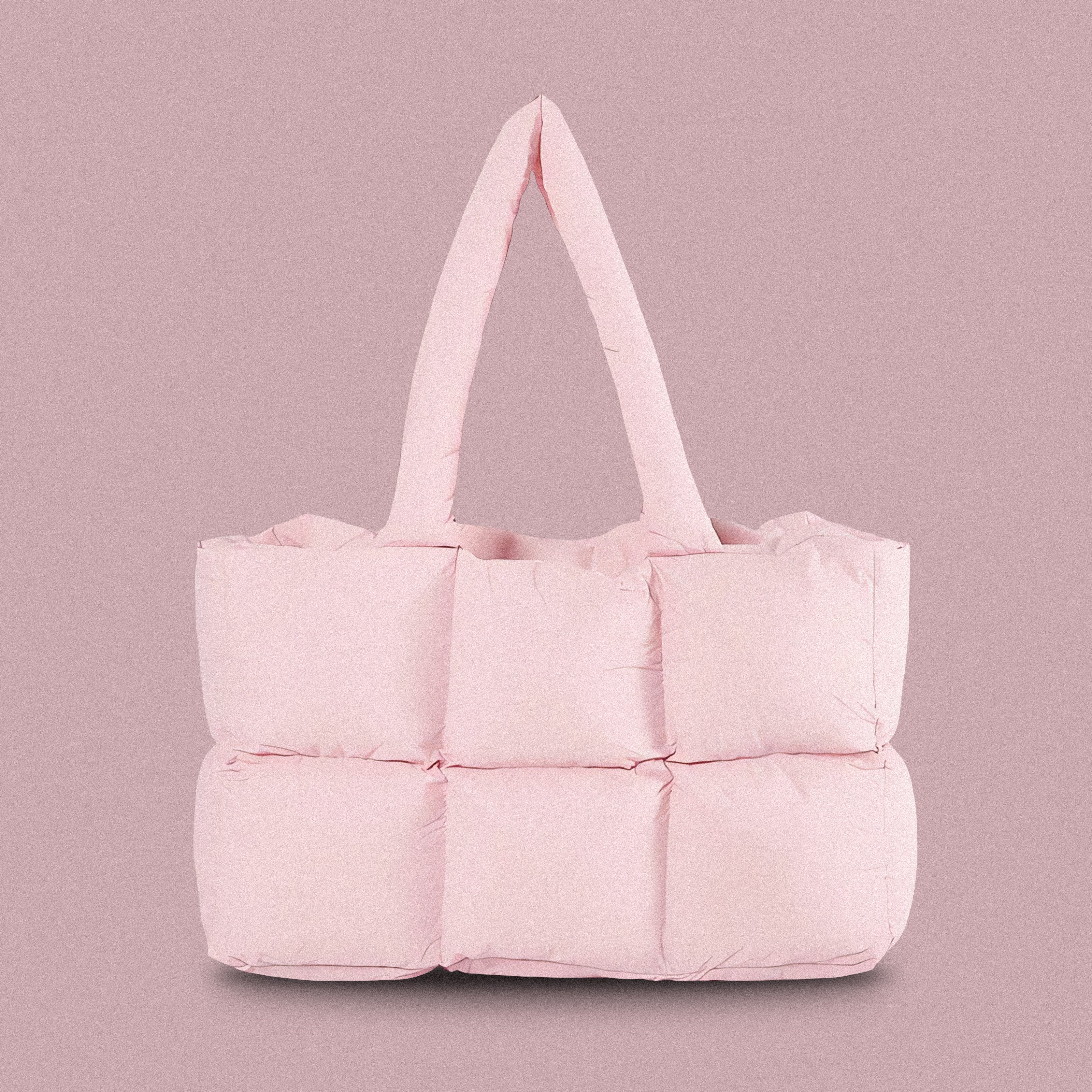 PLSH baby pink women's designer puffer handbag on a pink background