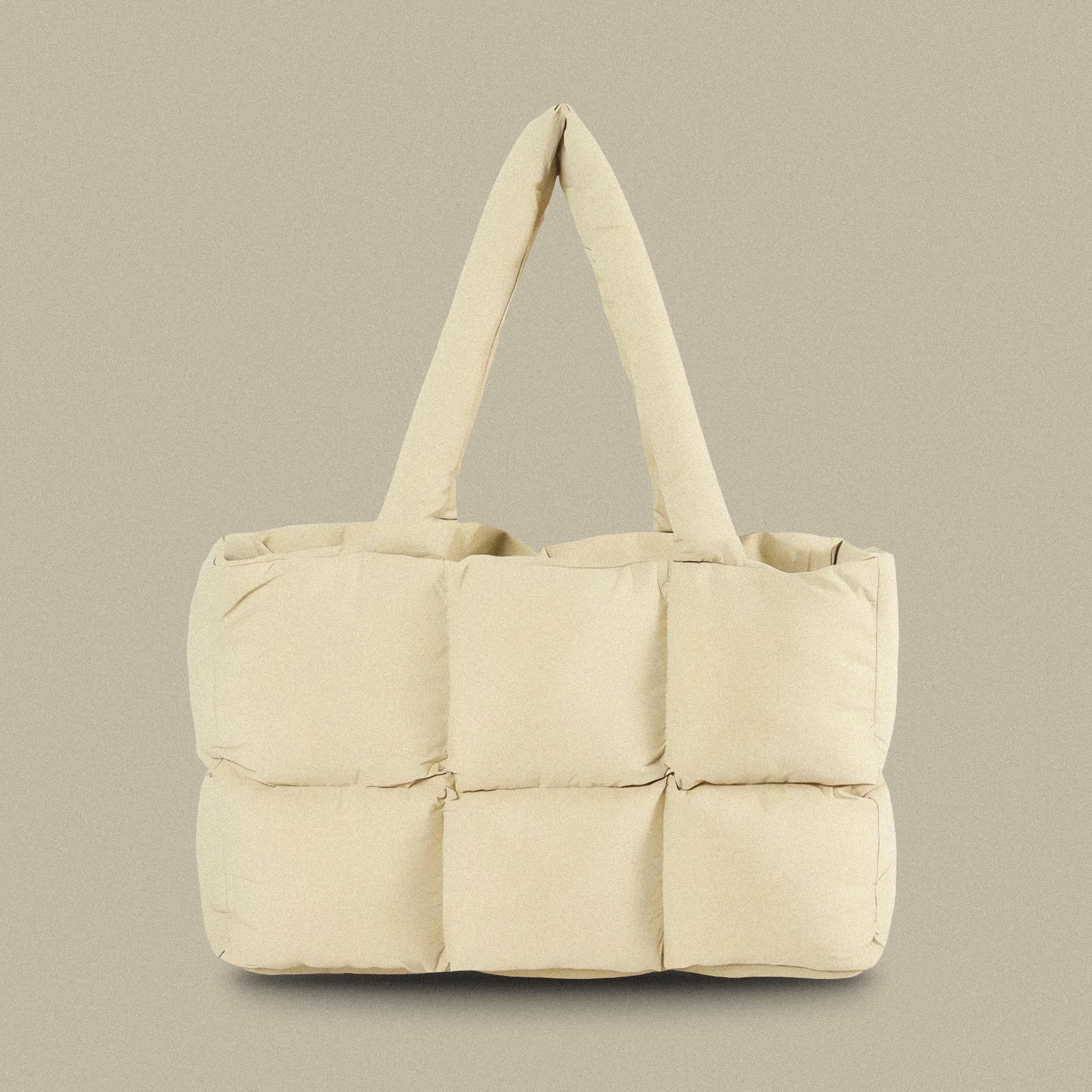 PLSH beige women's designer puffer handbag on a beige background