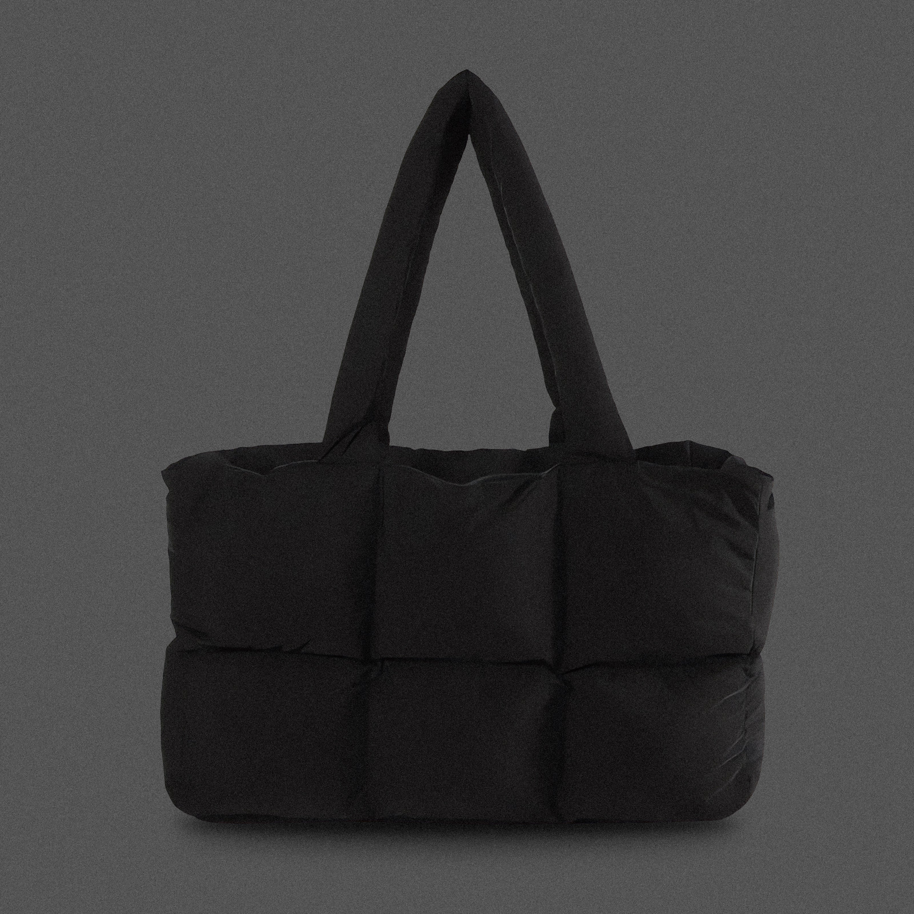 PLSH black women's designer puffer handbag on a gray background