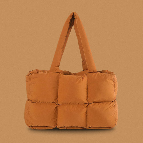 PLSH brown women's designer puffer handbag on a brown background