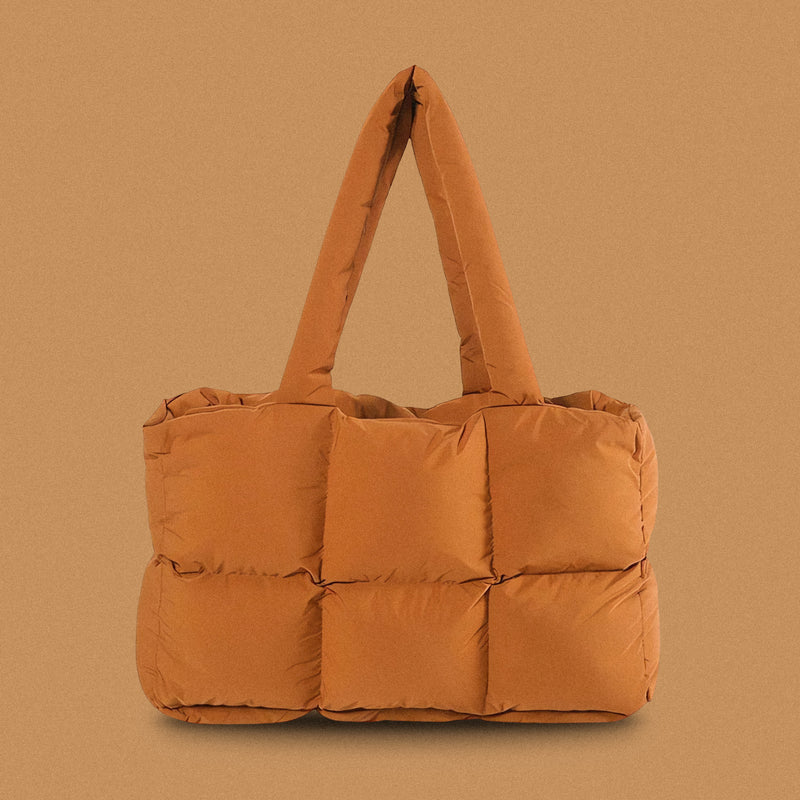 PLSH brown women's designer puffer handbag on a brown background