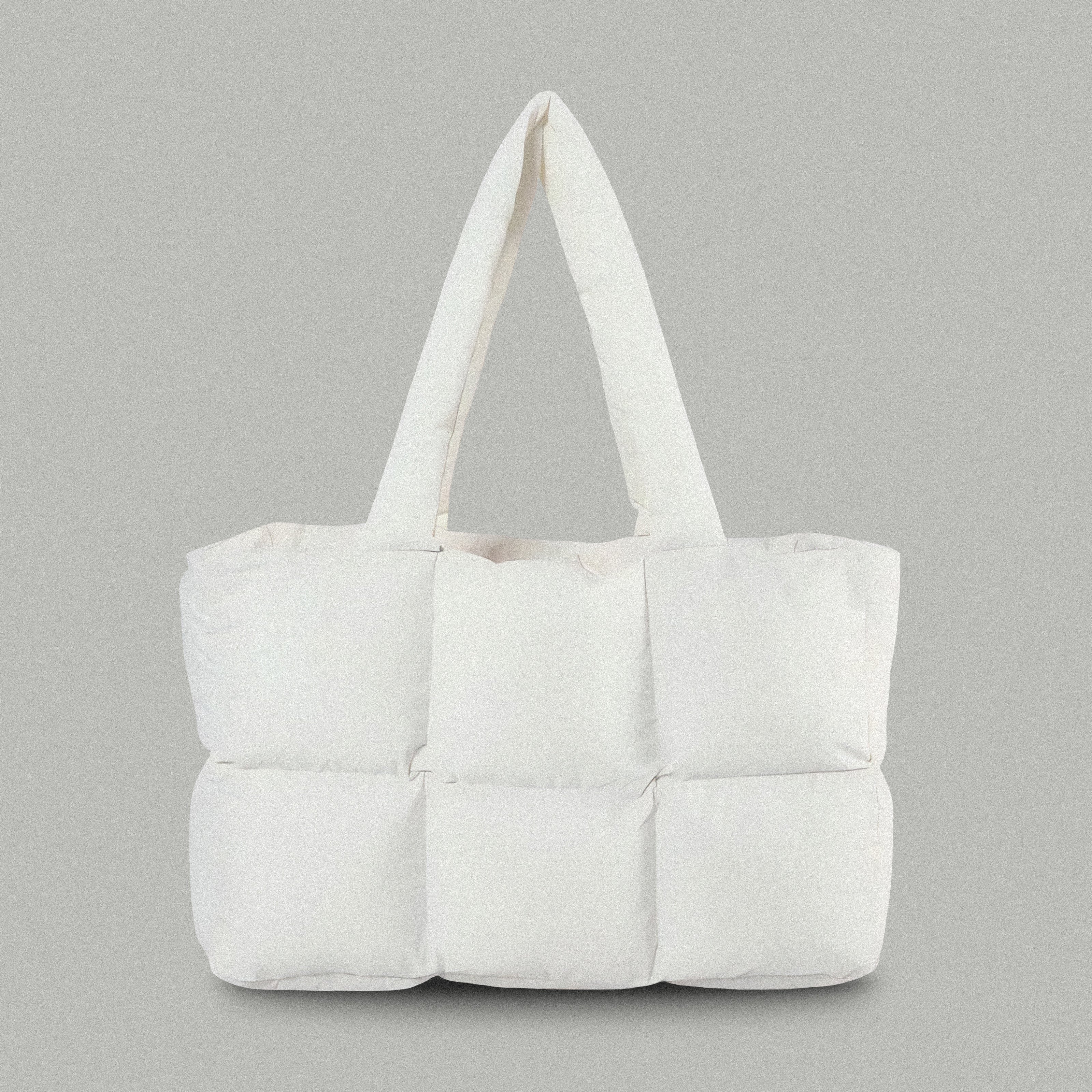 PLSH white women's designer puffer handbag on a gray background