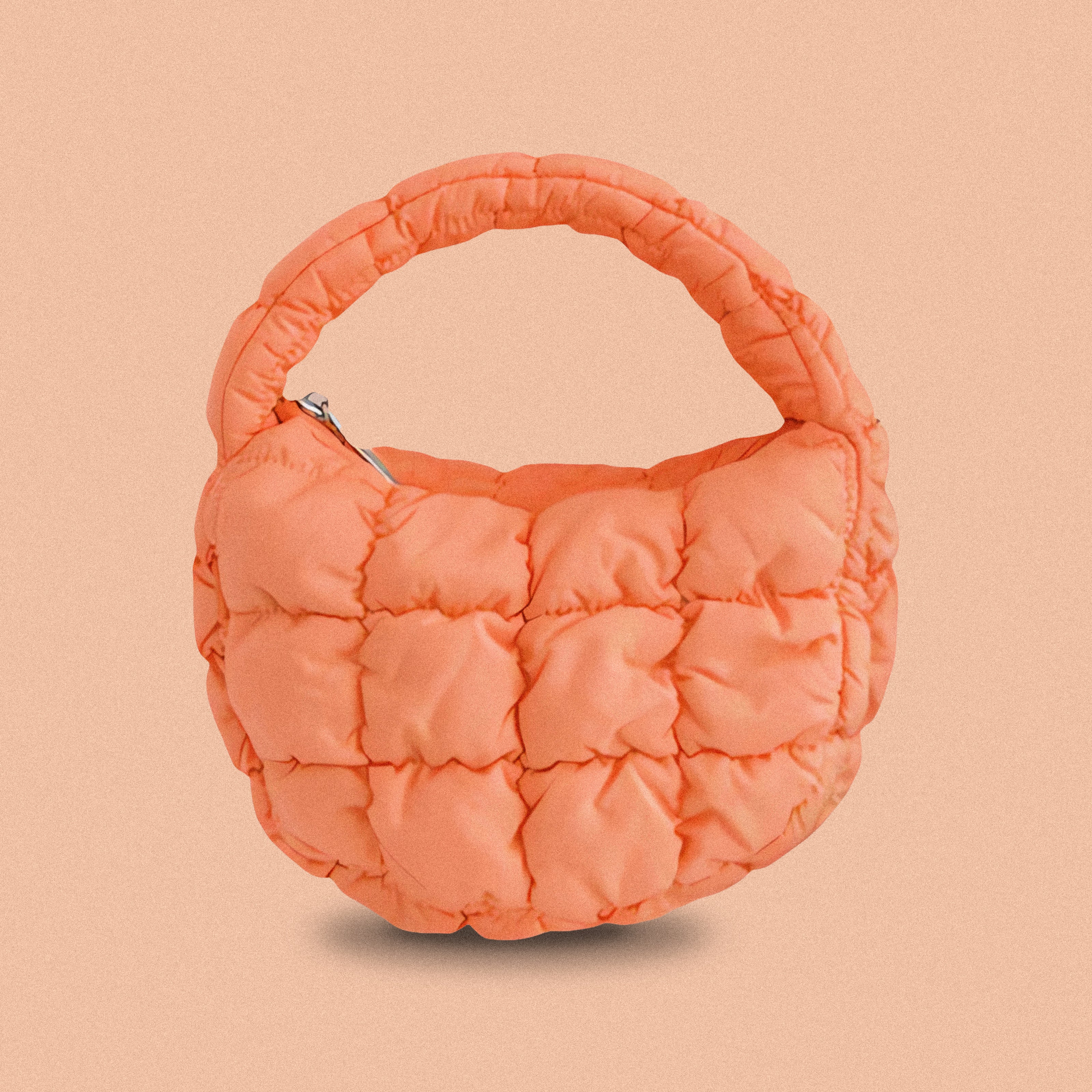 PLSH orange women’s designer puffer handbag on a orange background