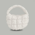 PLSH white women’s designer puffer handbag on a gray background