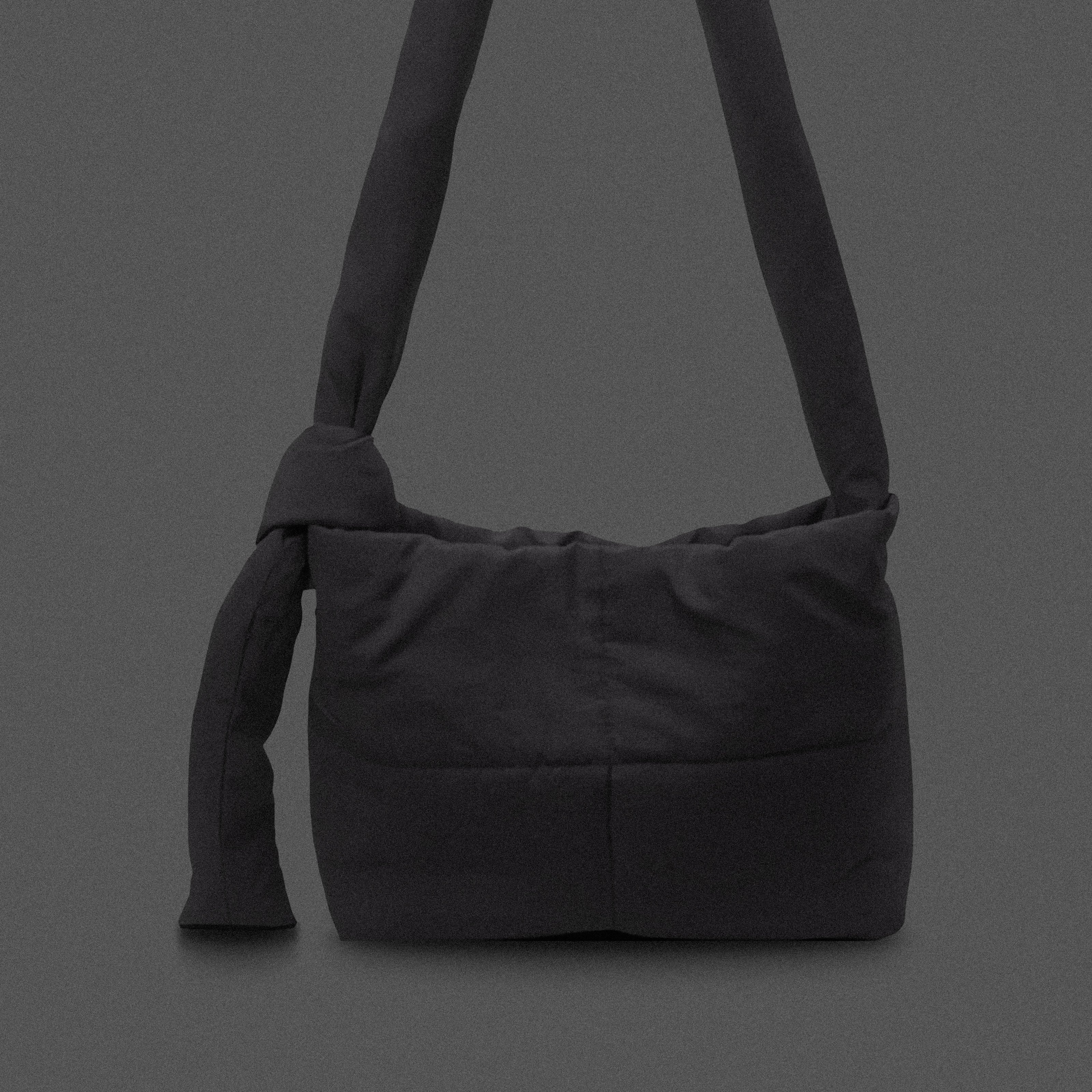 PLSH black women’s designer puffer handbag on a black background