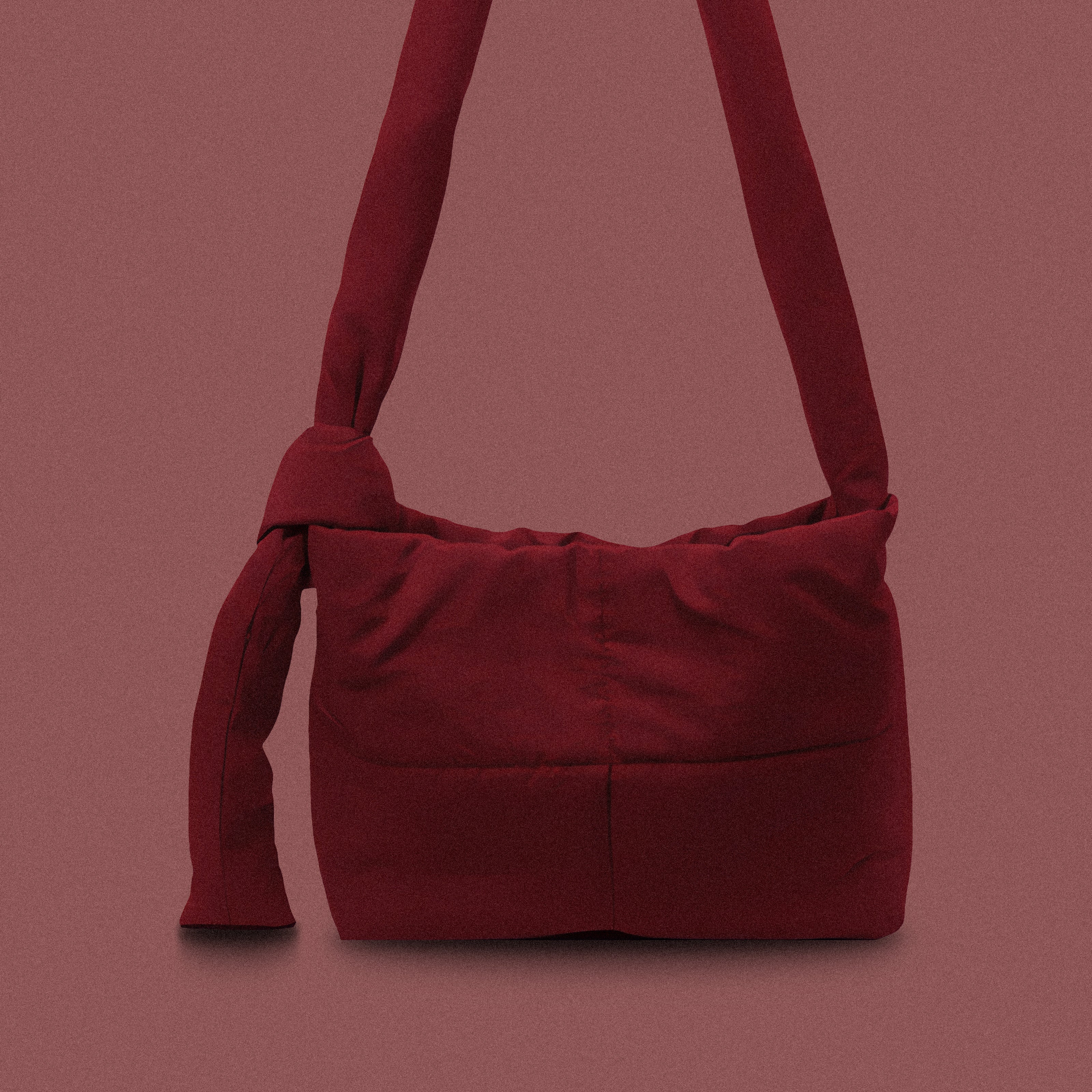 PLSH burgundy women’s designer puffer handbag on a burgundy background