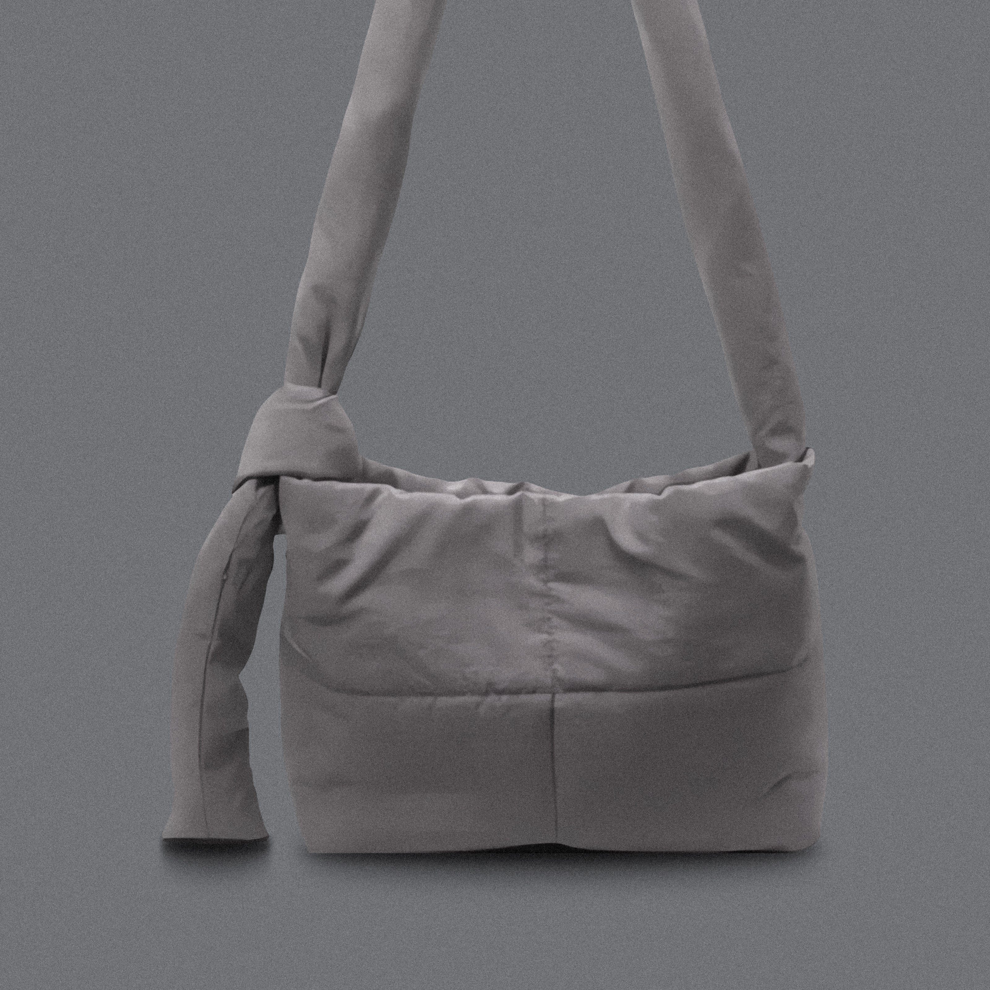 PLSH gray women’s designer puffer handbag on a gray background