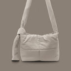 PLSH light gray women’s designer puffer handbag on a gray background
