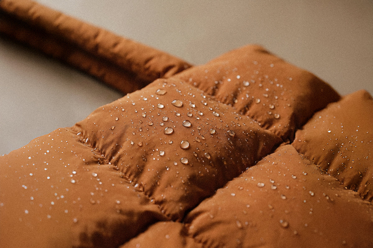 Close-up of PLSH women’s designer handbag in brown showcasing water resistant padded fabric