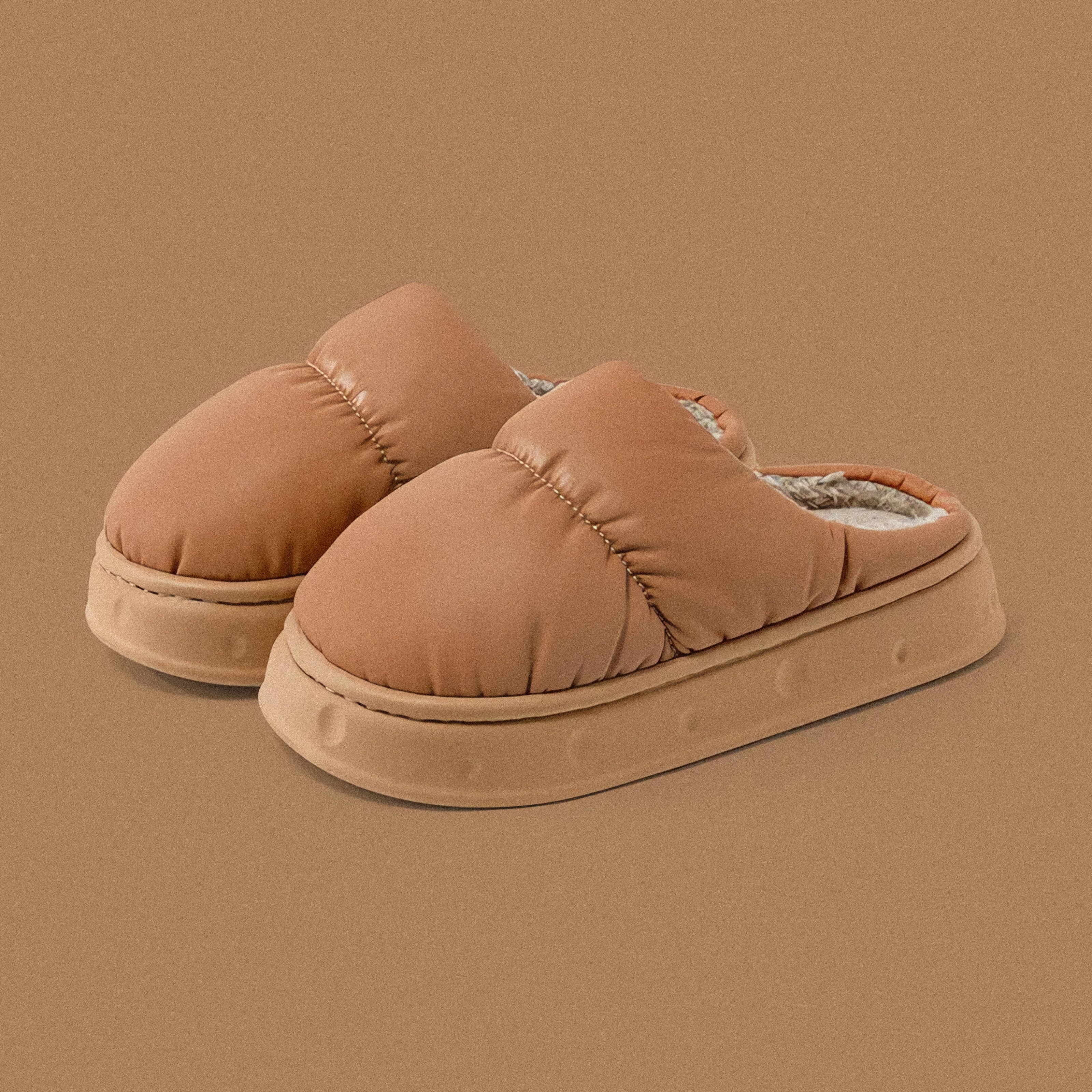 PLSH brown women’s premium puffer slippers on a brown background