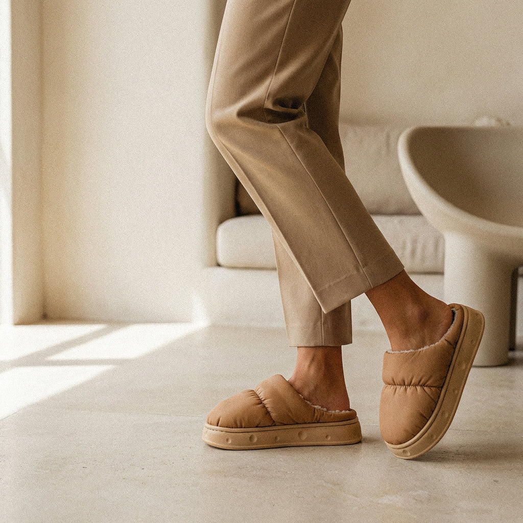 Woman wearing PLSH premium beige slippers and pants in a minimalistic room