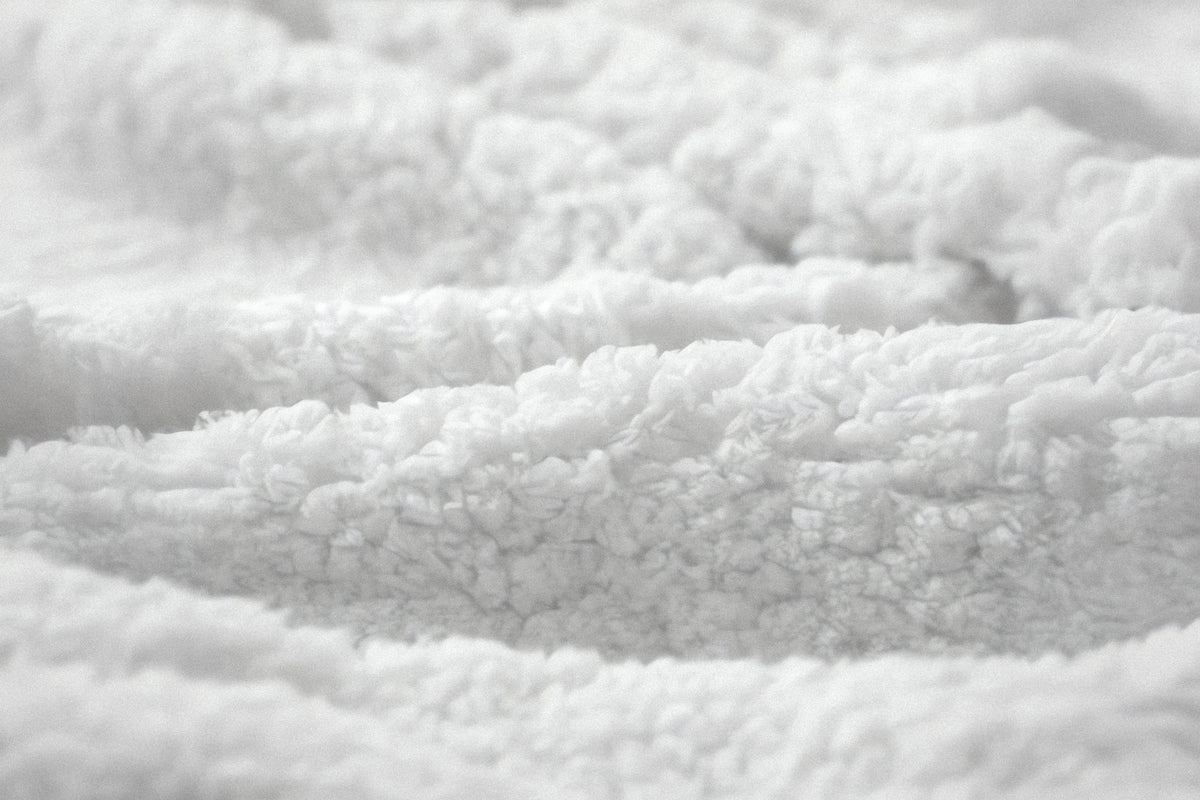 Close-up of PLSH premium women's slippers showing white fleece cotton material